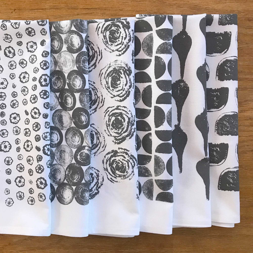 collection of folded veggie printed tea towels by Betsy Marie